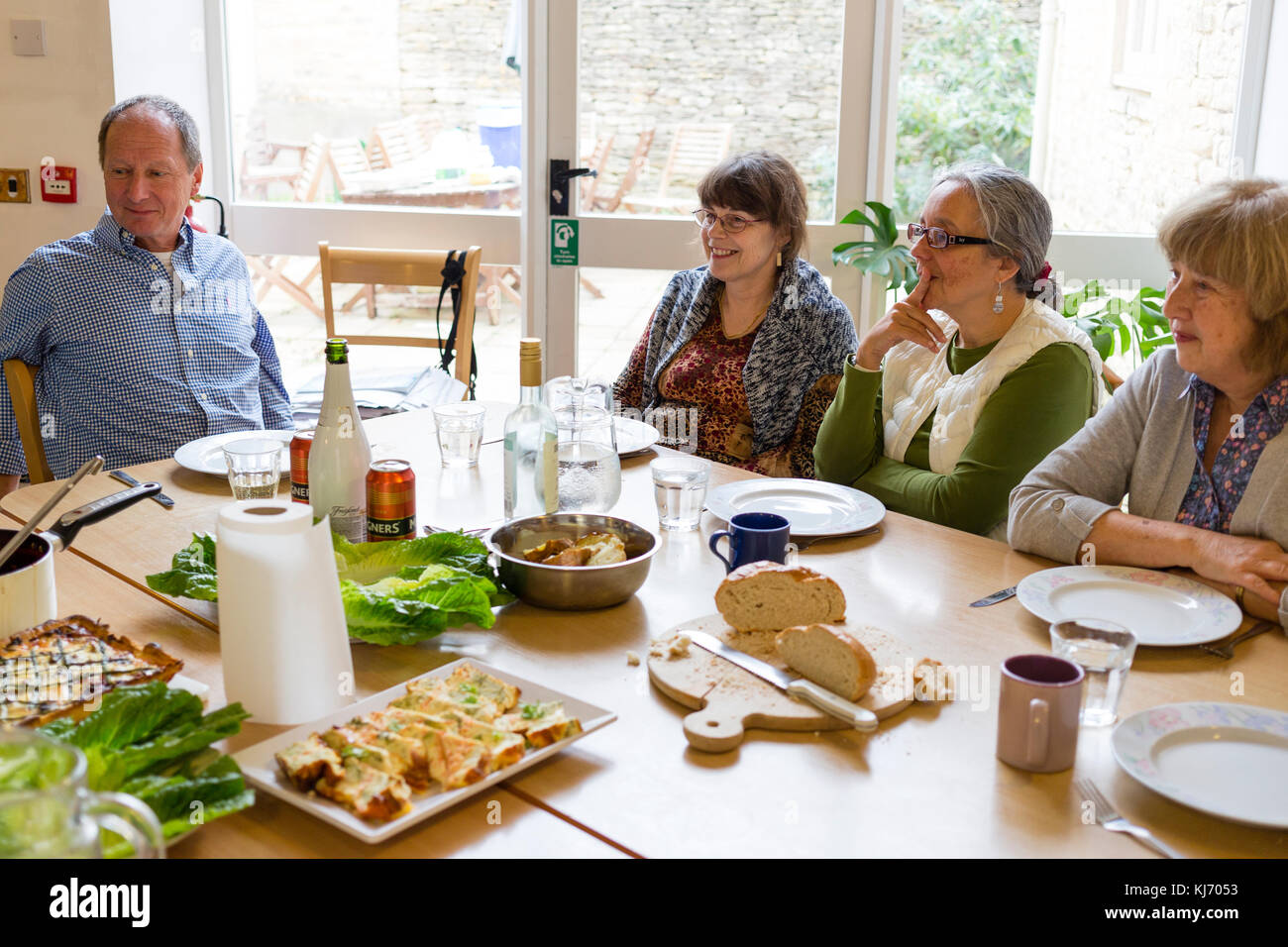 Older people eating together in communal kitchen, England, UK Stock Photo