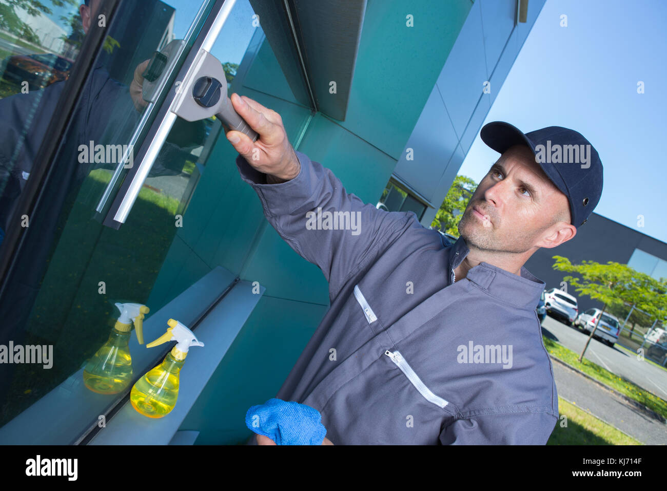 man cleaning windows with squeegee Stock Photo Alamy