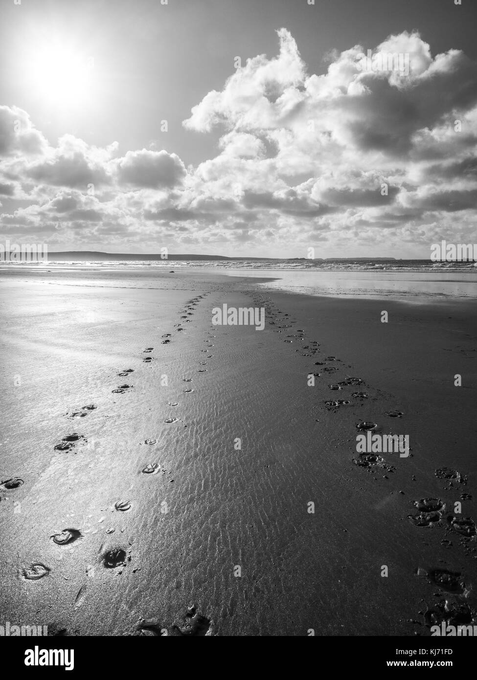 Footsteps across the sand towards the sea at Druidstone Beach Pembrokeshire National Park Wales at Low tide Stock Photo