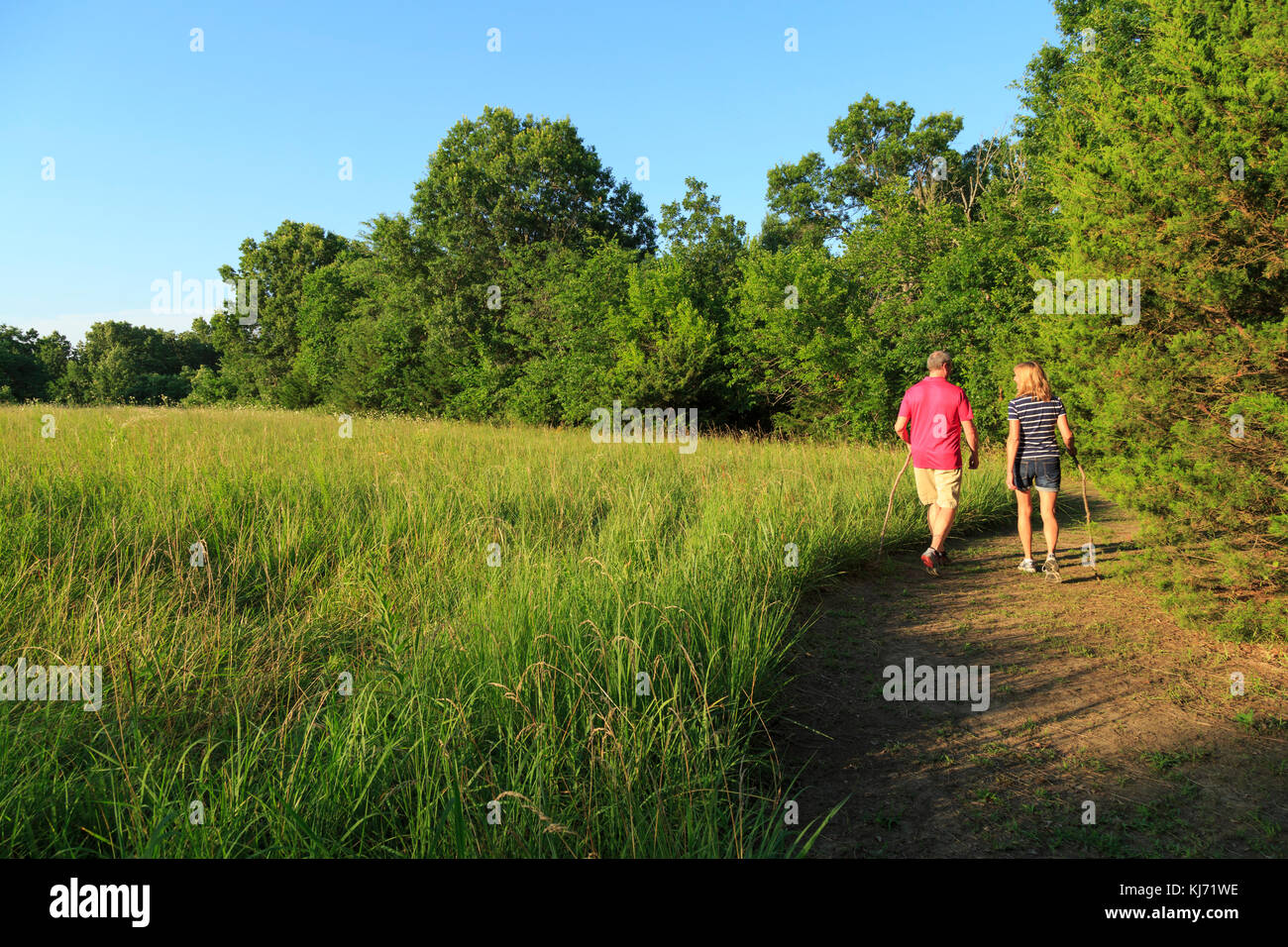 Couple in 40s walking on path by Kansas field ,  Cedar Crest Lodge, Pleasanton, Kansas, USA Stock Photo
