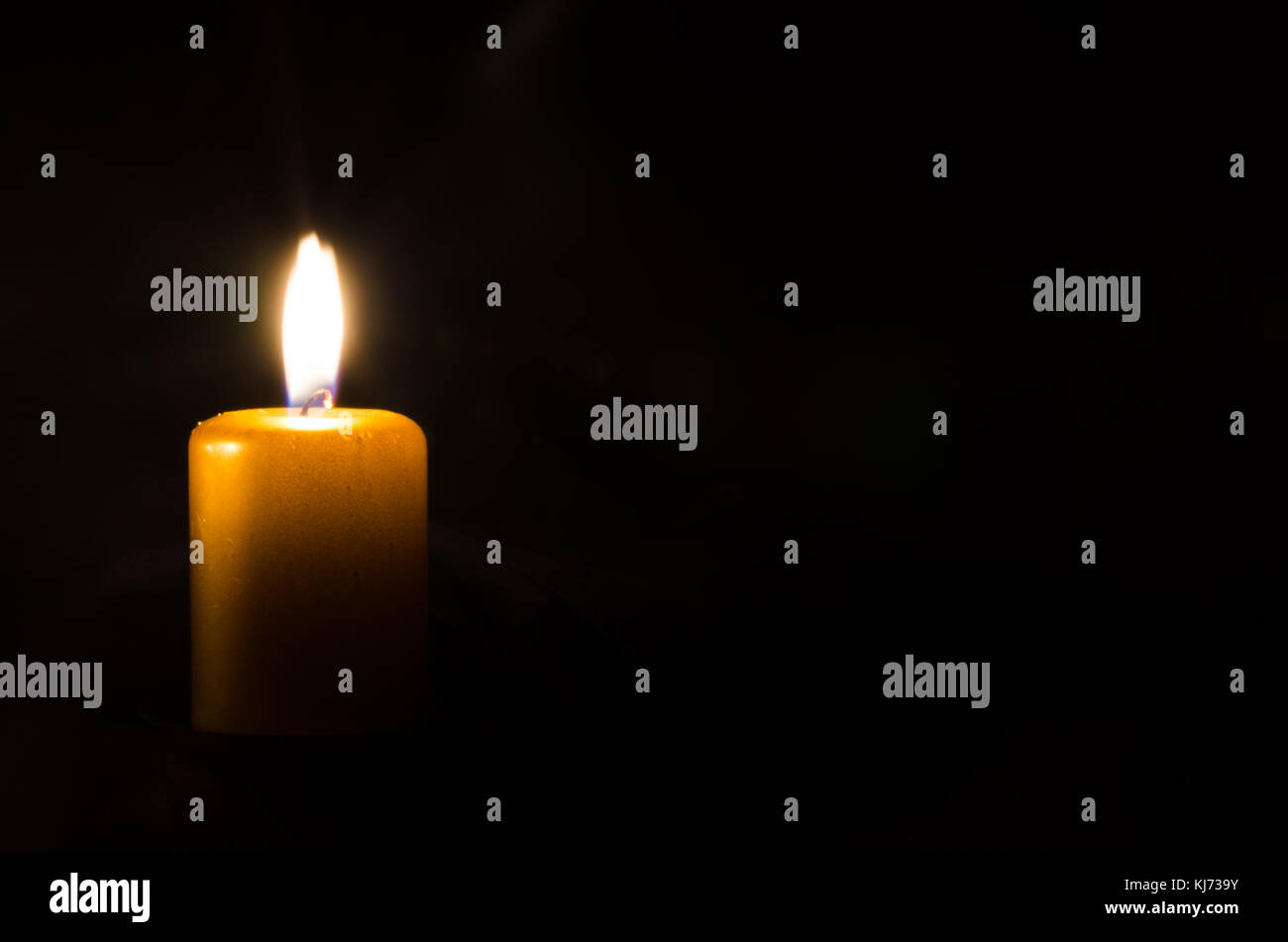 one burning candle decoration against black background Stock Photo Alamy