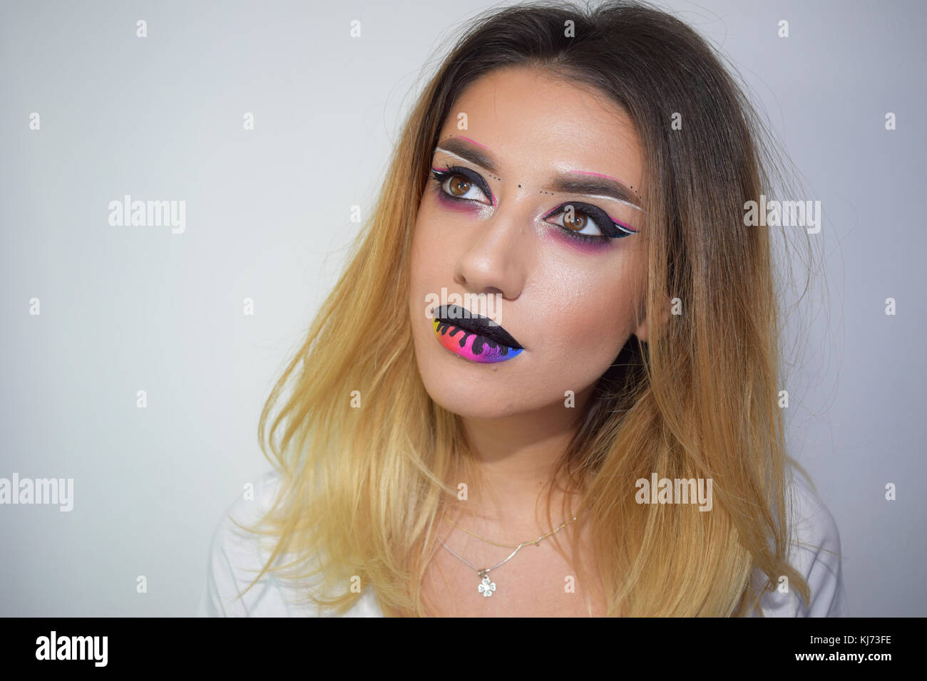 Pure art makeup including melting rainbow lips, a lollipop and a beautiful model Stock Photo
