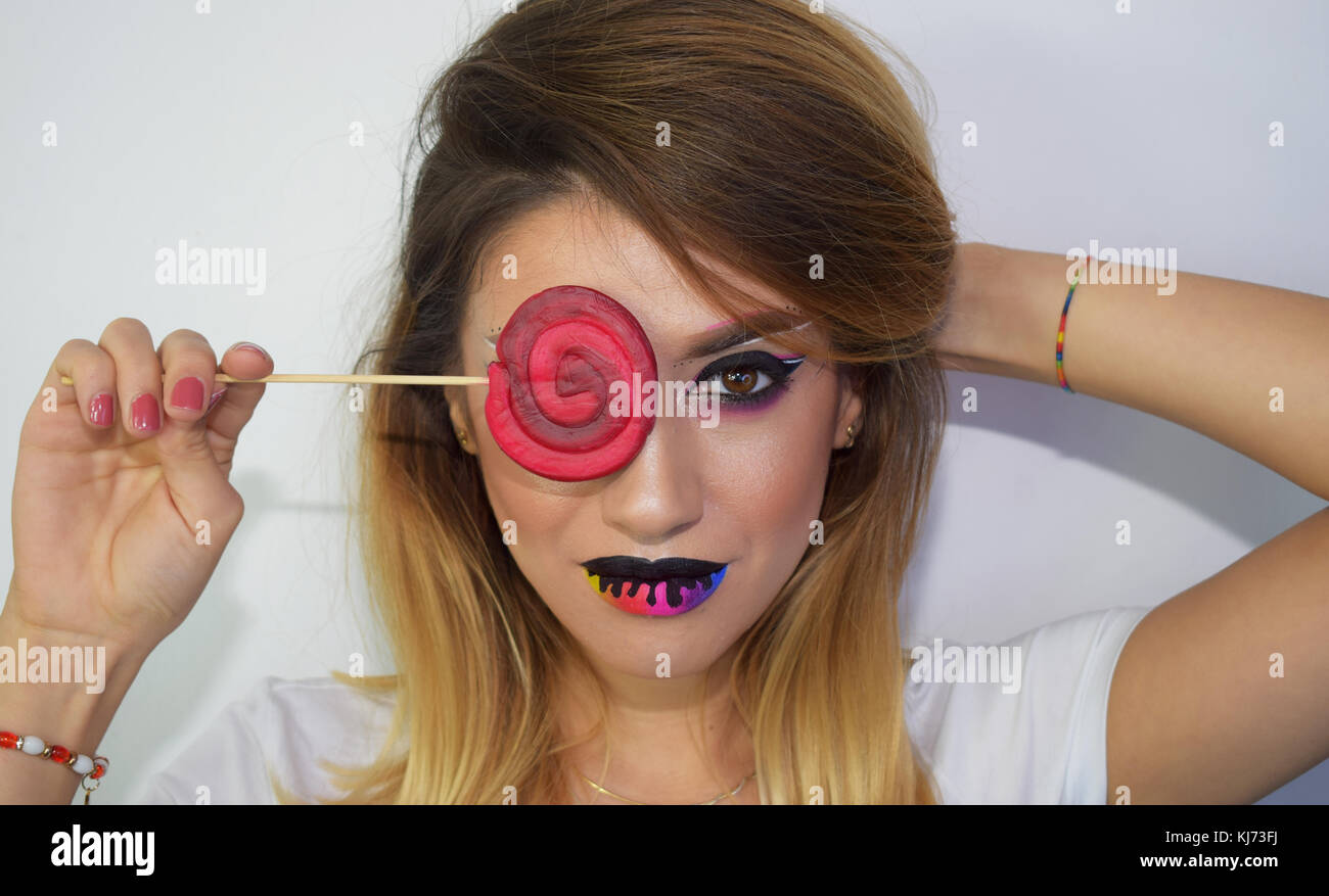 Pure art makeup including melting rainbow lips, a lollipop and a beautiful model Stock Photo