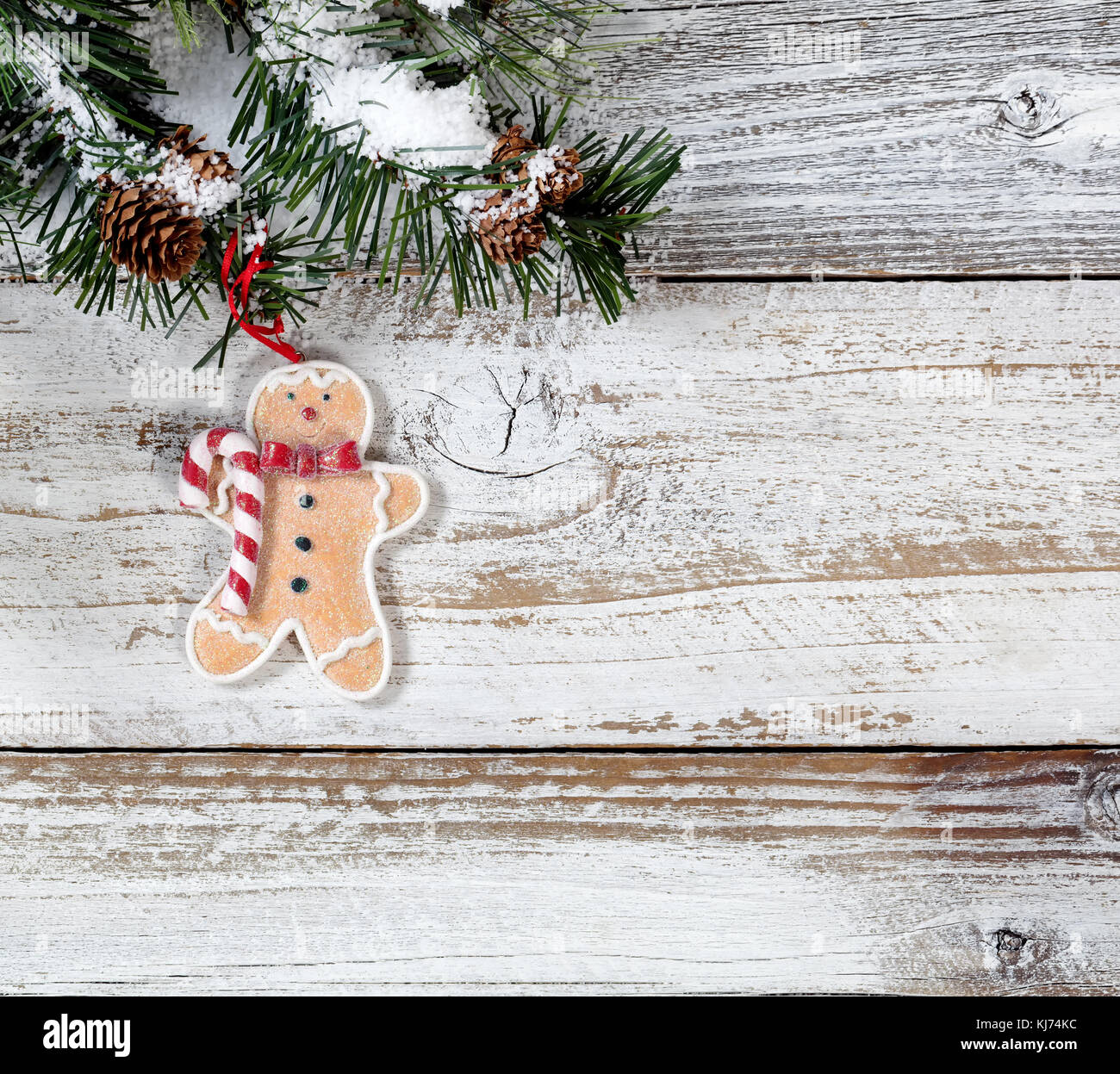 Christmas cookie ornament hanging in rough fir tree branch on rustic white wooden background Stock Photo