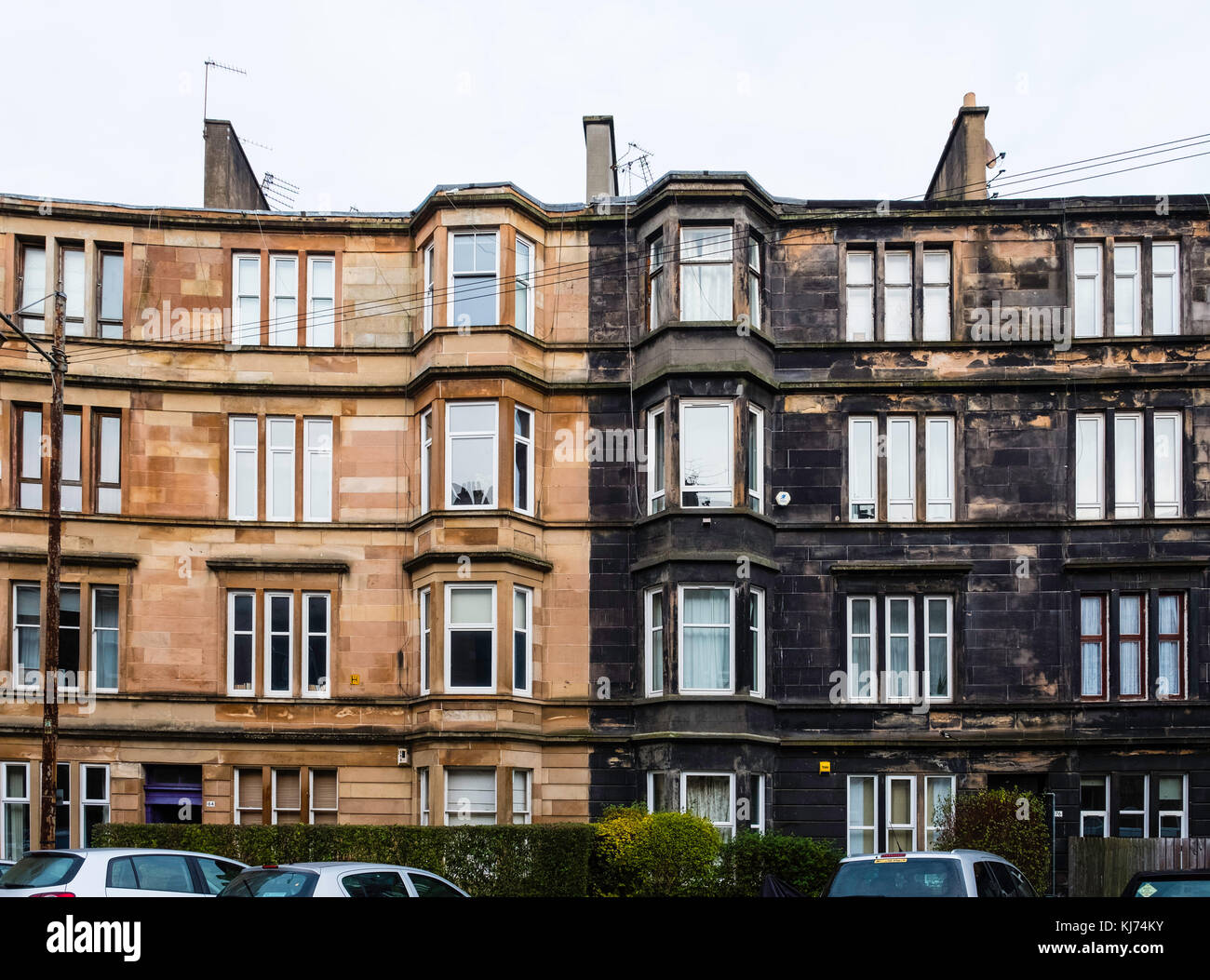View of typical  sandstone tenement apartment buildings , one after cleaning and the other without cleaning still showing black sooty discolouration i Stock Photo