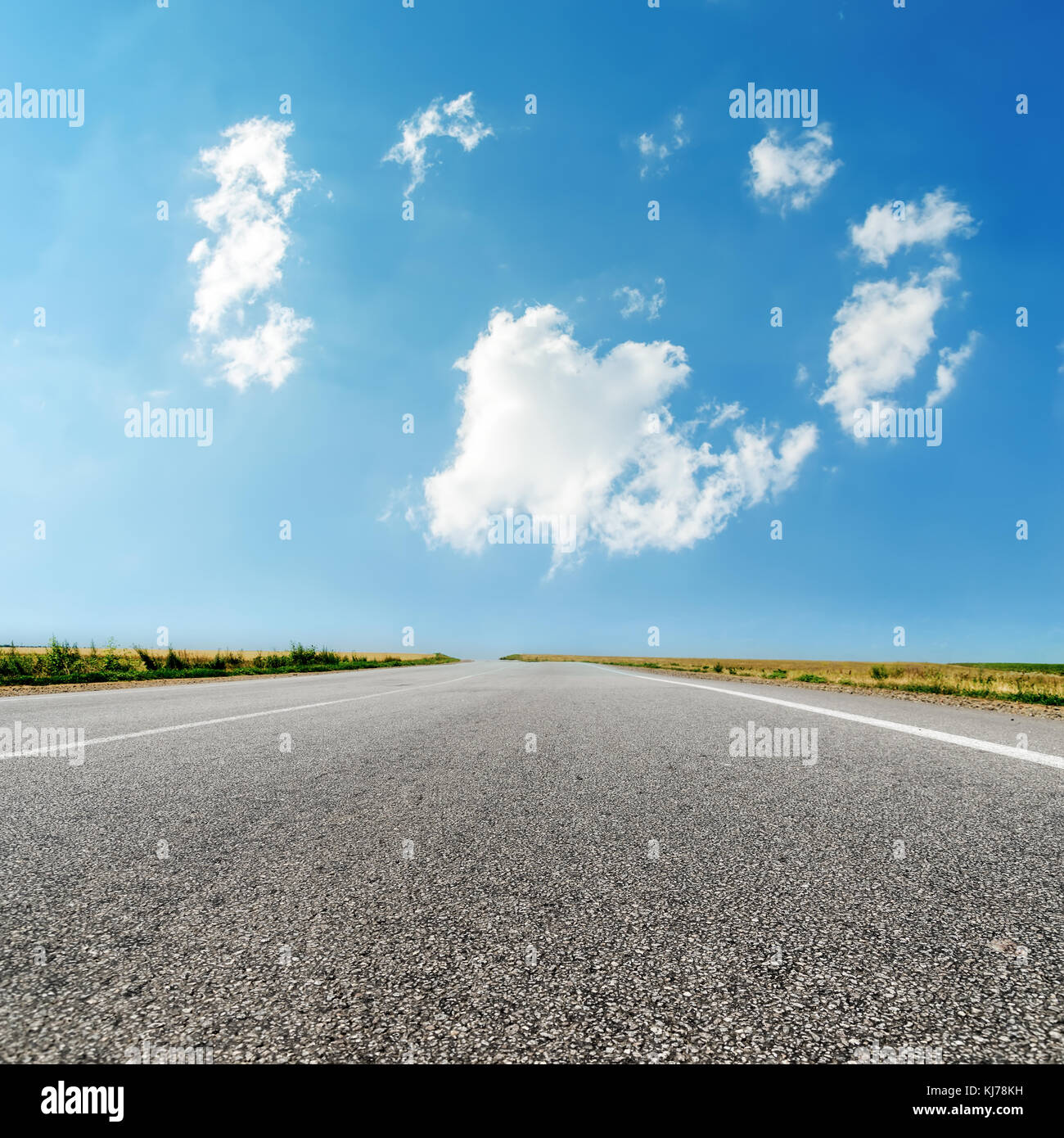 asphalt road closeup and clouds in blue sky Stock Photo - Alamy
