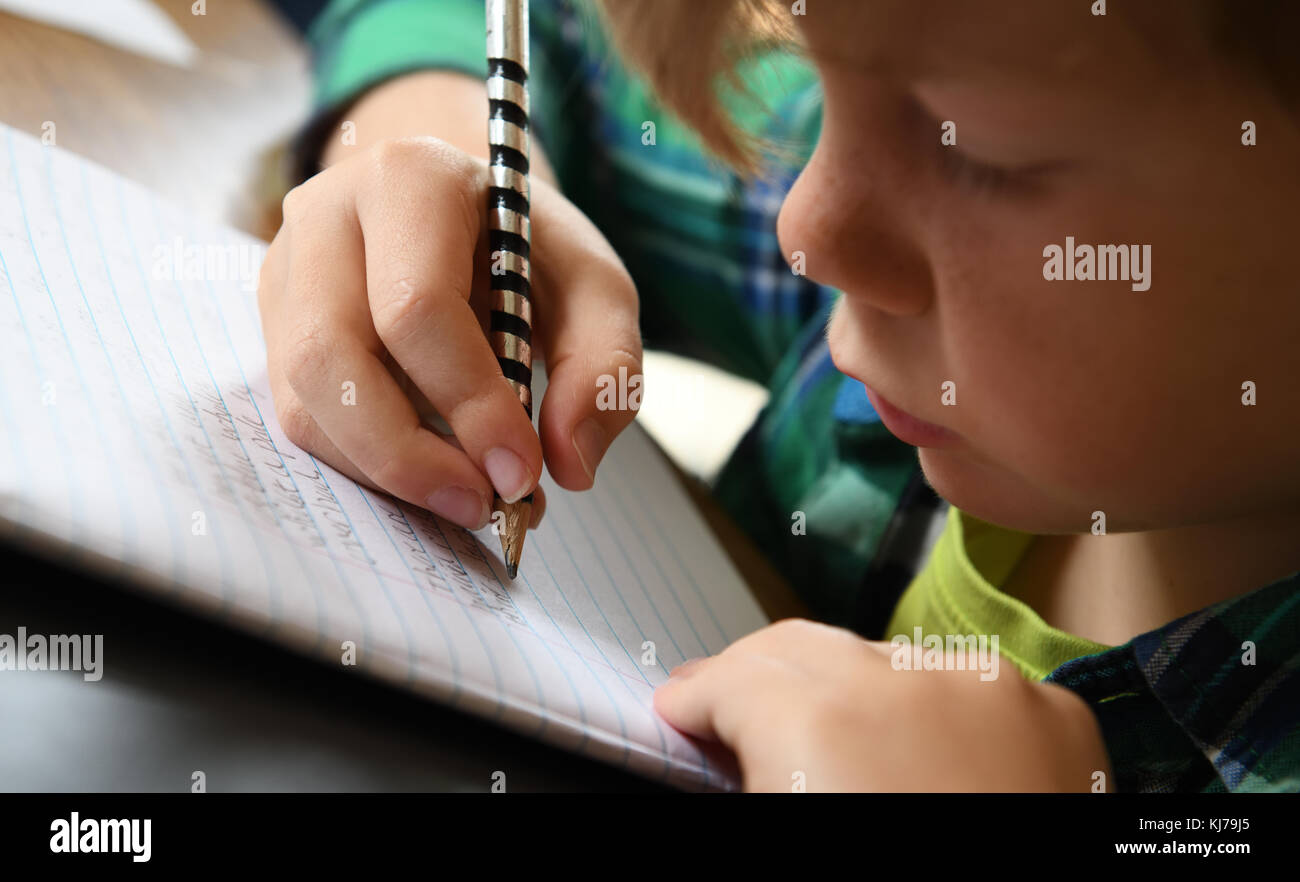 A young boy working hard on his homework Stock Photo