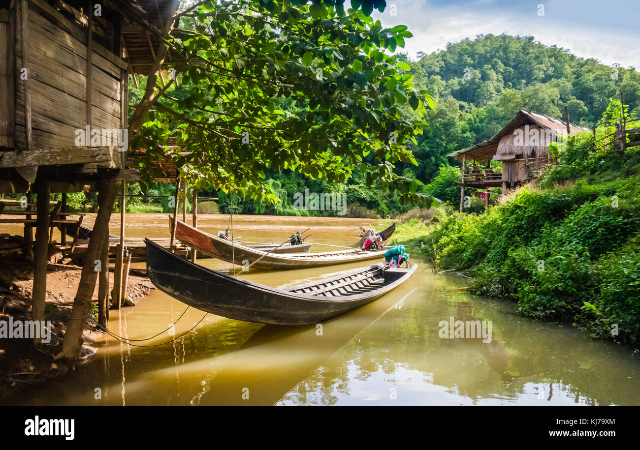 Long-tail boats moored in a village of stilt houses, Thailand Stock Photo