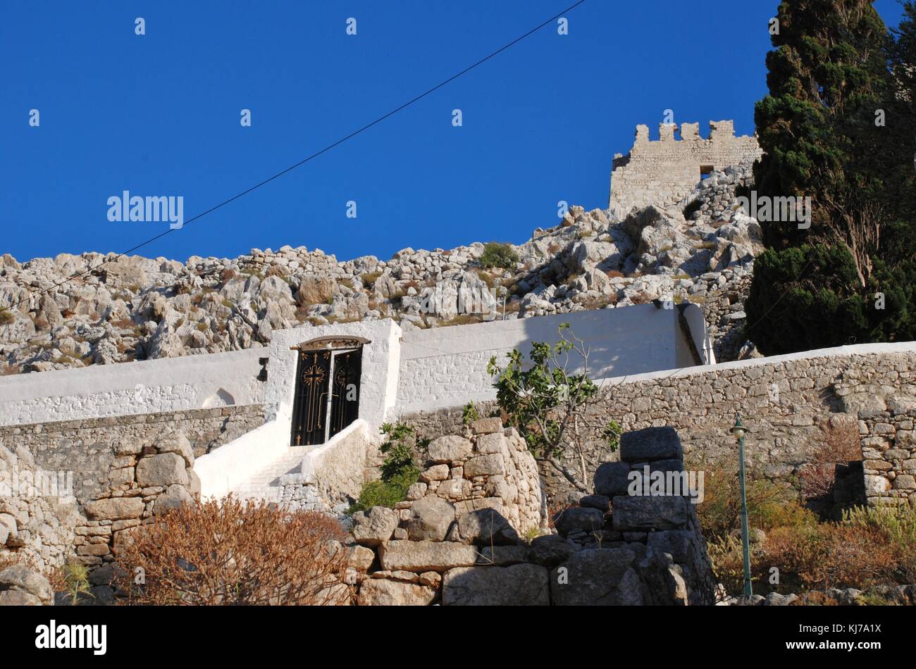 The church of the Panagia (Virgin Mary) with the medieval Crusader Knights castle above at Chorio on the Greek island of Halki. Stock Photo