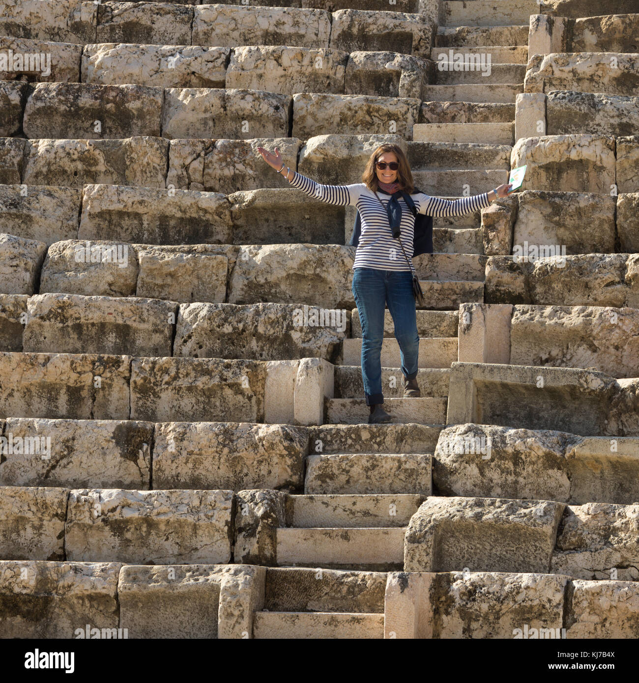 Happy woman standing on stone steps at Roman amphitheater, Bet She'an National Park, Haifa District, Israel Stock Photo