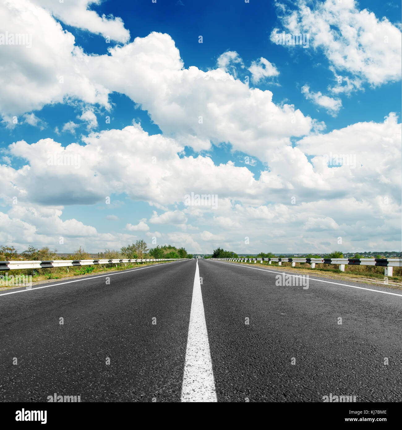 asphalt road to horizon and clouds in blue sky Stock Photo - Alamy