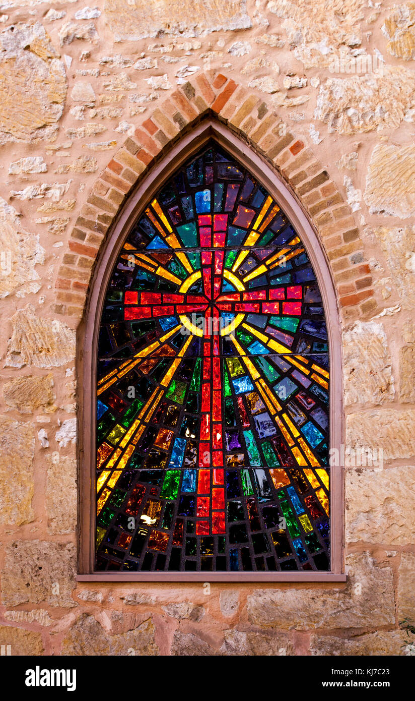 Gothic style church window with stained glass/ red cross made of stained glass Stock Photo
