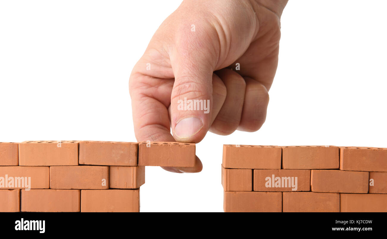 adding brick to a gap in the wall isolated on a white background Stock Photo