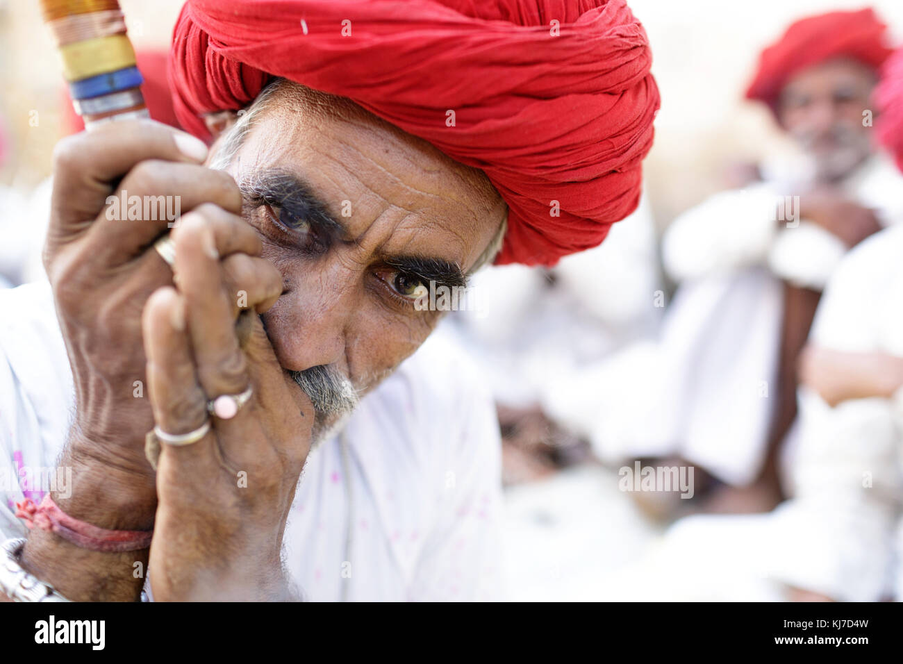 Member of ethnic minority - elder Rabari man in red turban smoking clay pipe. Photo taken at countryside near Jodhpur, Rajasthan, India. Stock Photo