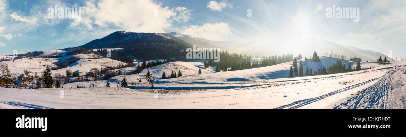 forested valley of Pylypets village in Carpathians. Gorgeous winter landscape with Borzhava mountain ridge on winter sunny day Stock Photo