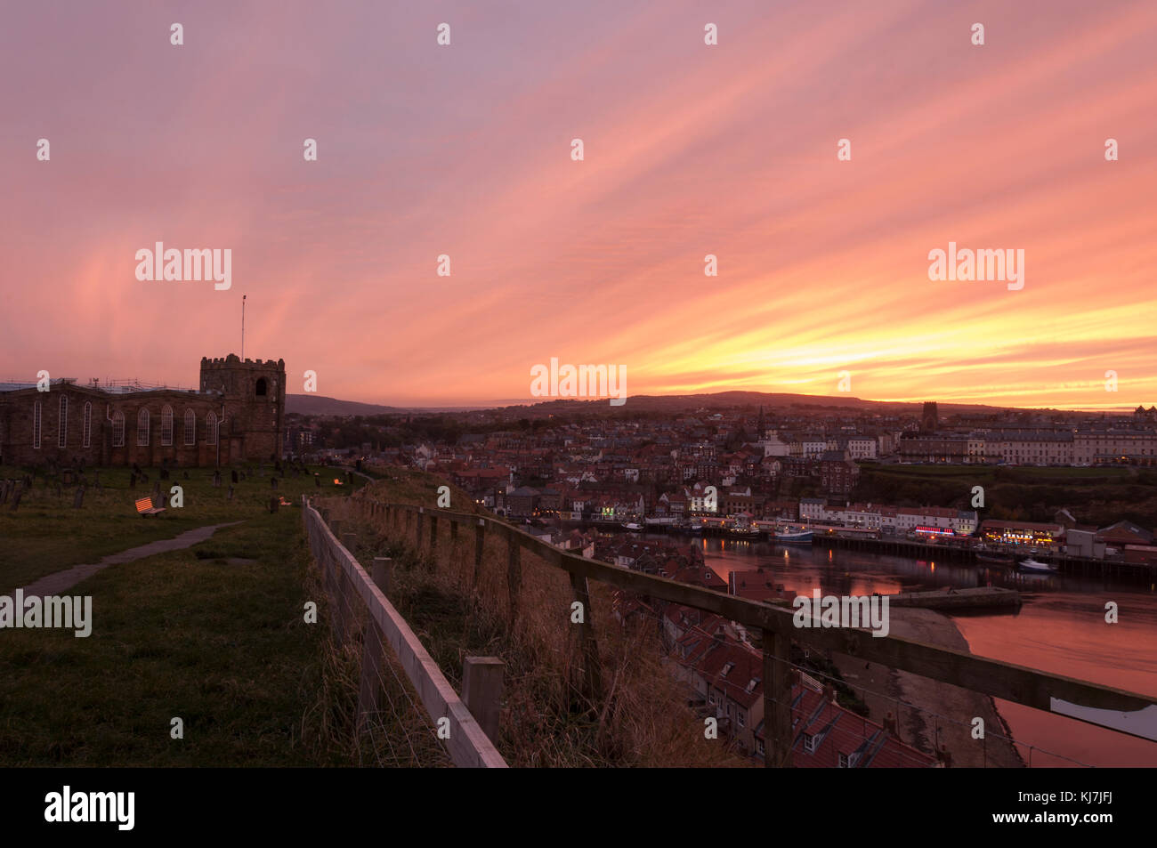 Whitby in North Yorkshire, as the sky lights up with color on an October evening in Autumn, looking to the St Mary Church and the harbour. Stock Photo