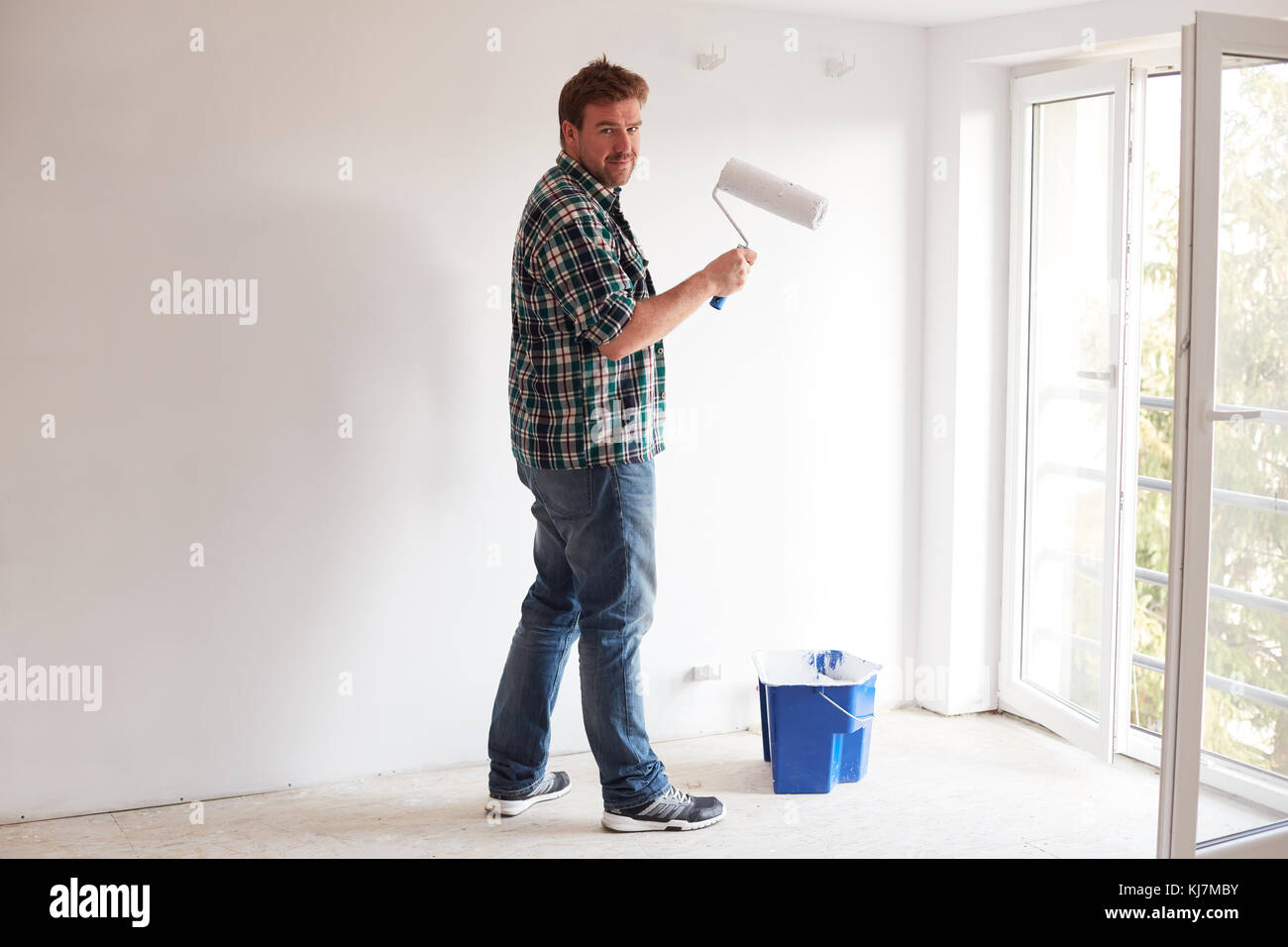 Young man painting a wall on white in a modern home Stock Photo