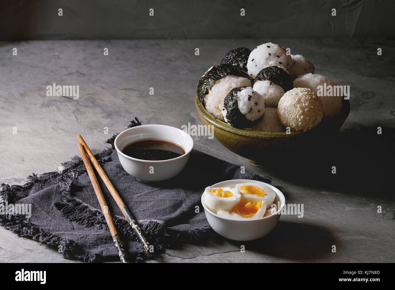 Bowl with different size rice balls with black sesame and seaweed nori, served with soft boiled