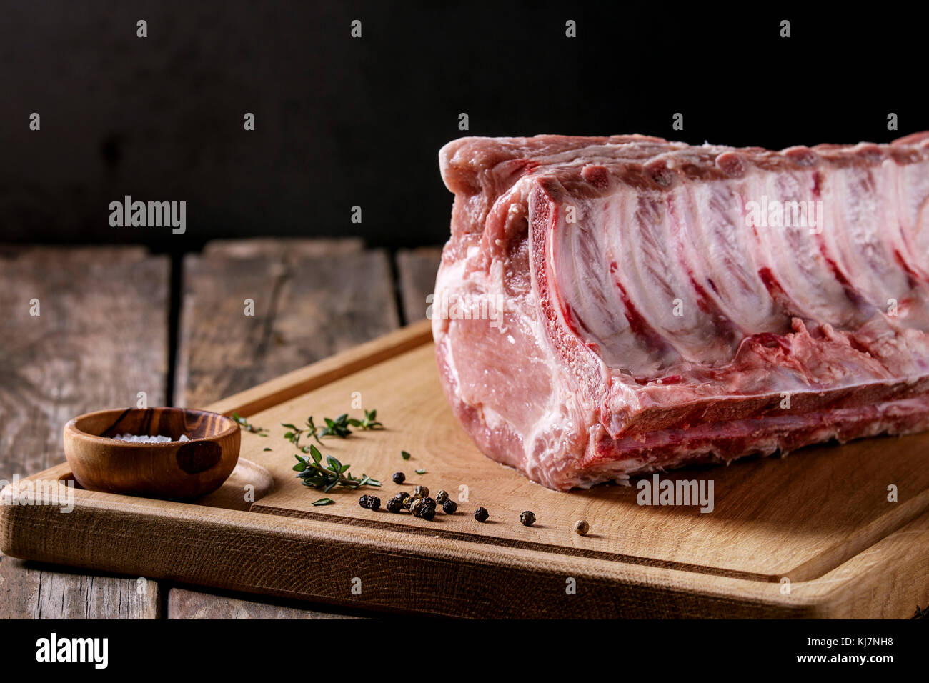 Fresh raw uncooked whole rack of pork loin with ribs on wooden cutting