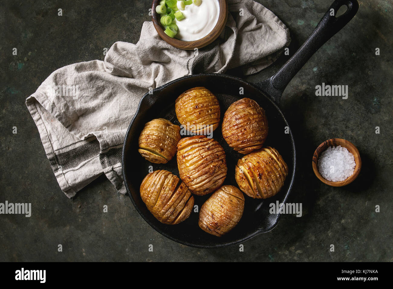Accordion hasselback baked potatoes served in castiron pan with sea