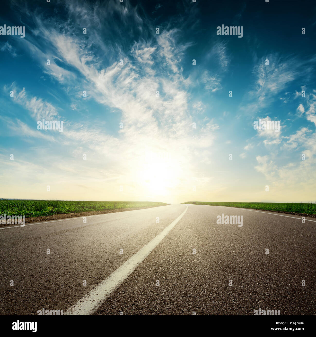 sunset in clouds over asphalt road Stock Photo - Alamy