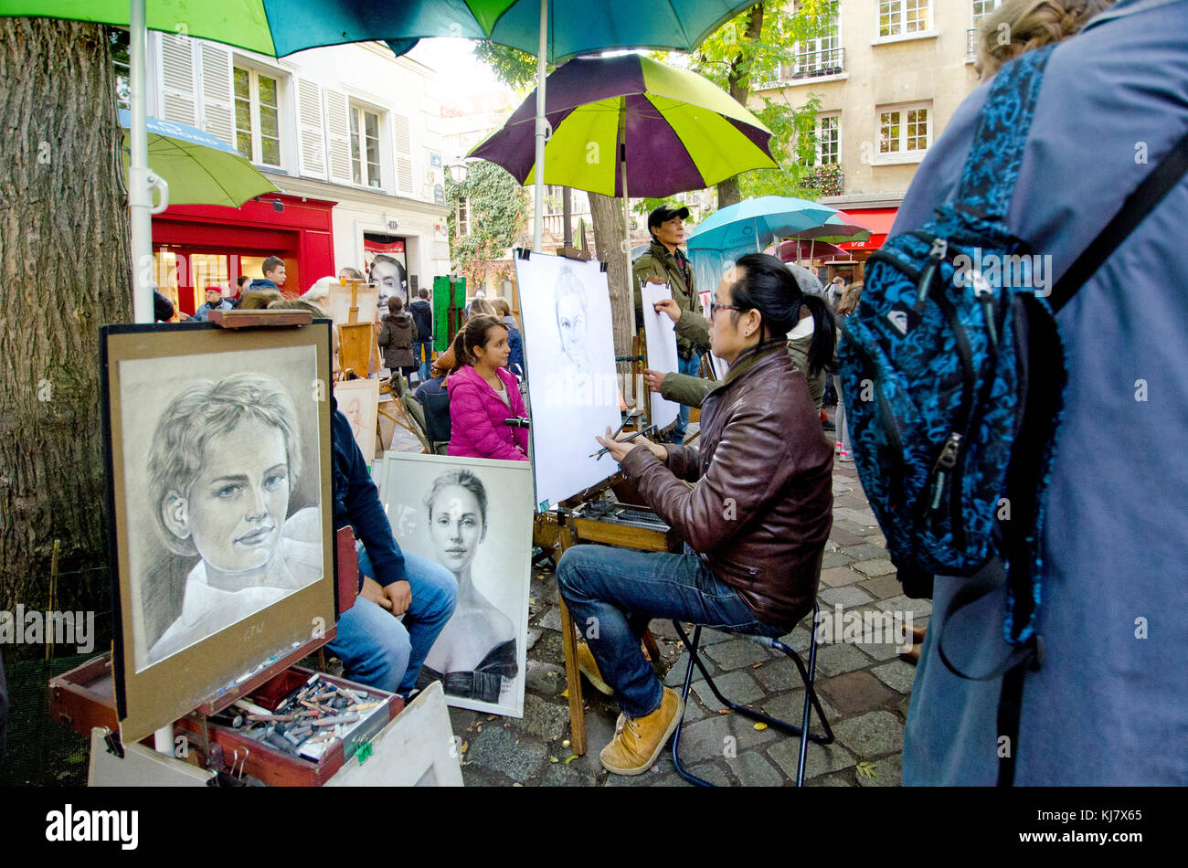 Paris, France. Montmartre - Place du Tertre - artist painting a tourist's portrait / caricature Stock Photo