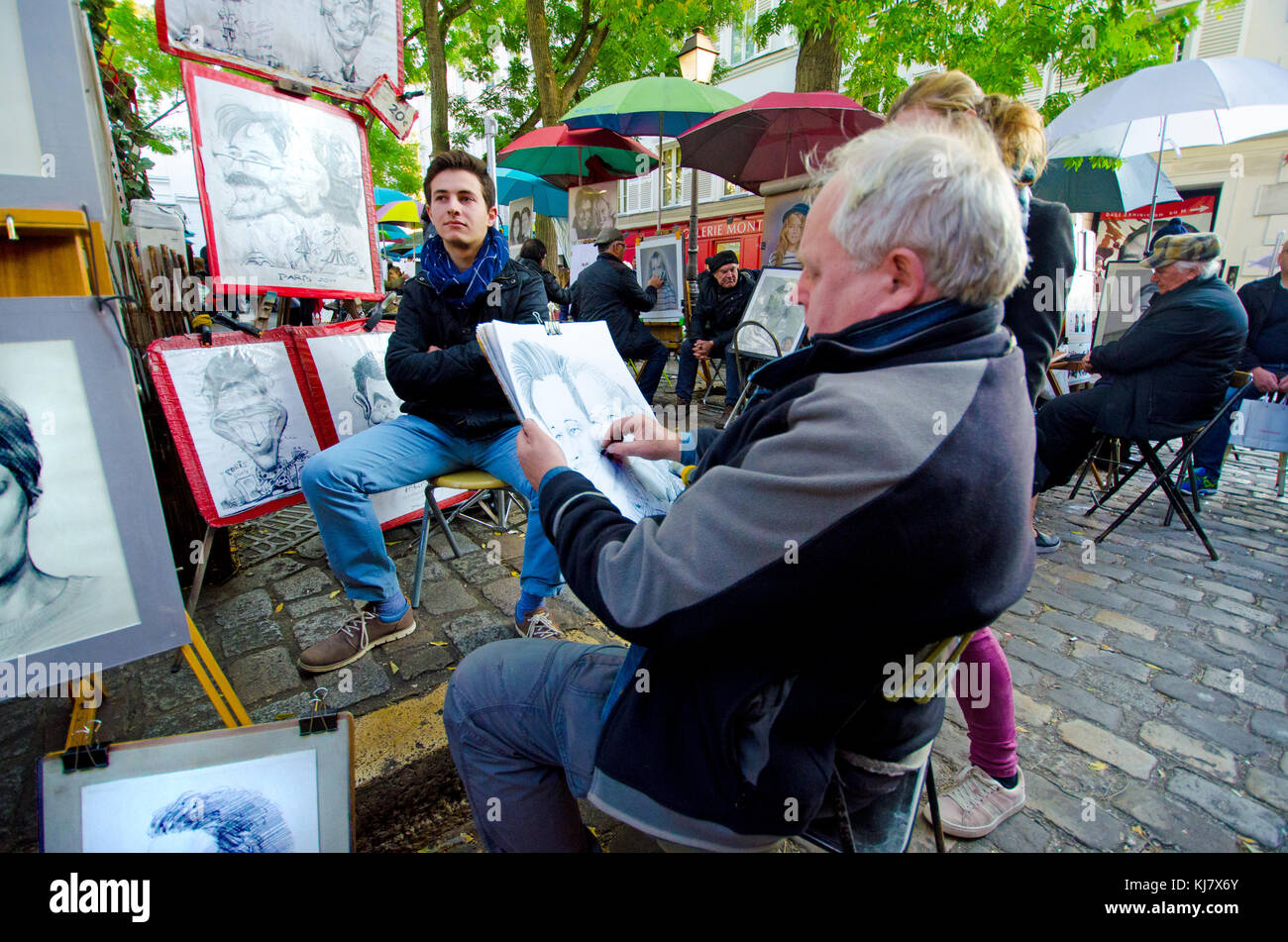 Paris, France. Montmartre - Place du Tertre - artist painting a tourist's portrait / caricature Stock Photo