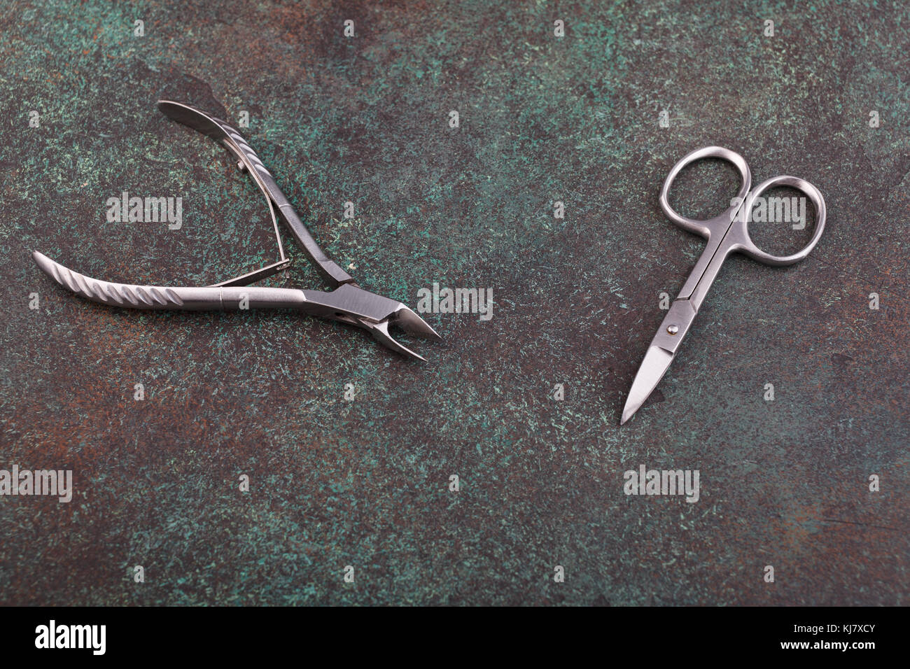 manicure scissors and nippers on a textured dark background Stock Photo