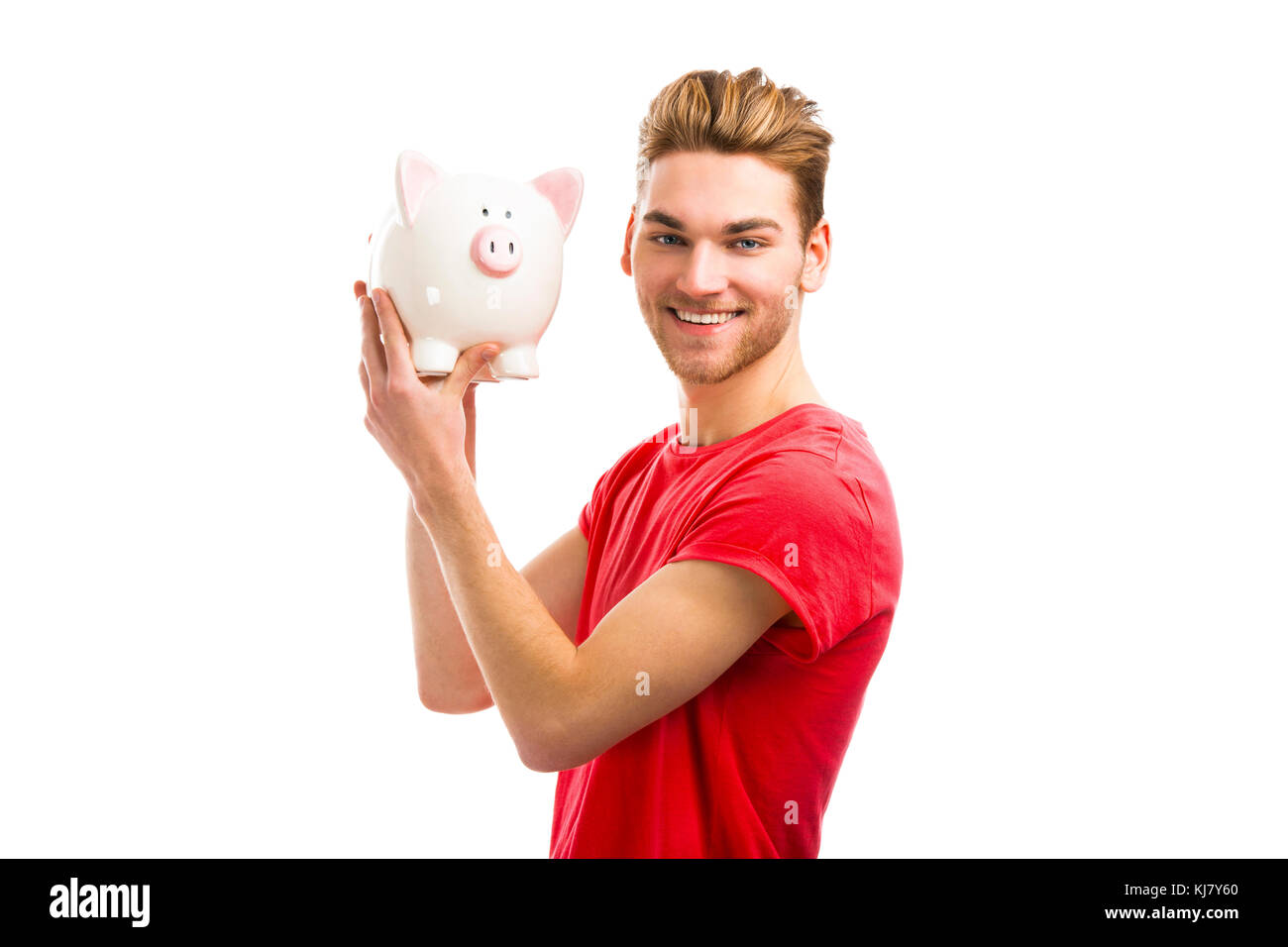 Handsome young man holding a piggy bank and smiling Stock Photo - Alamy