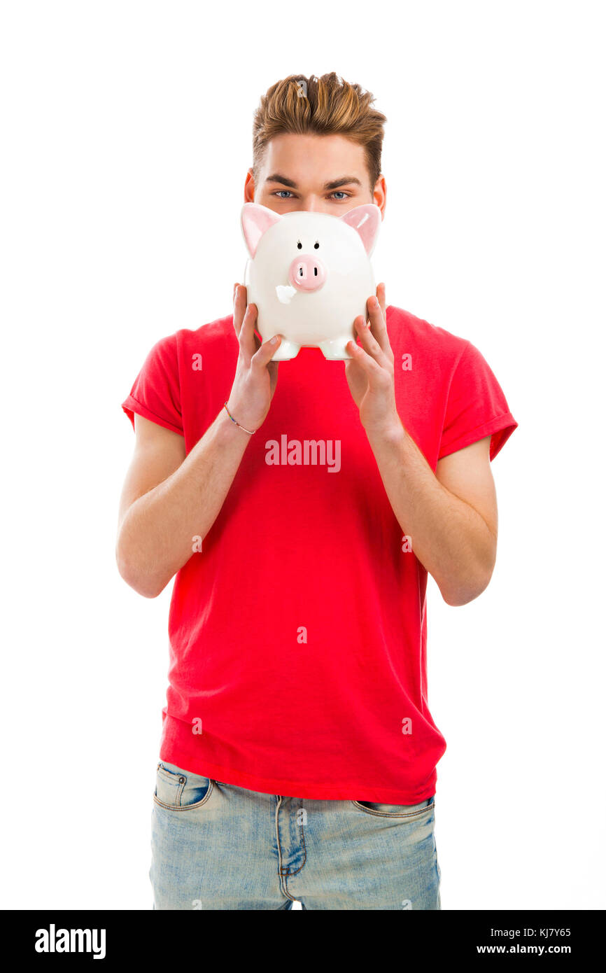 Handsome young man holding a piggy bank and smiling Stock Photo - Alamy