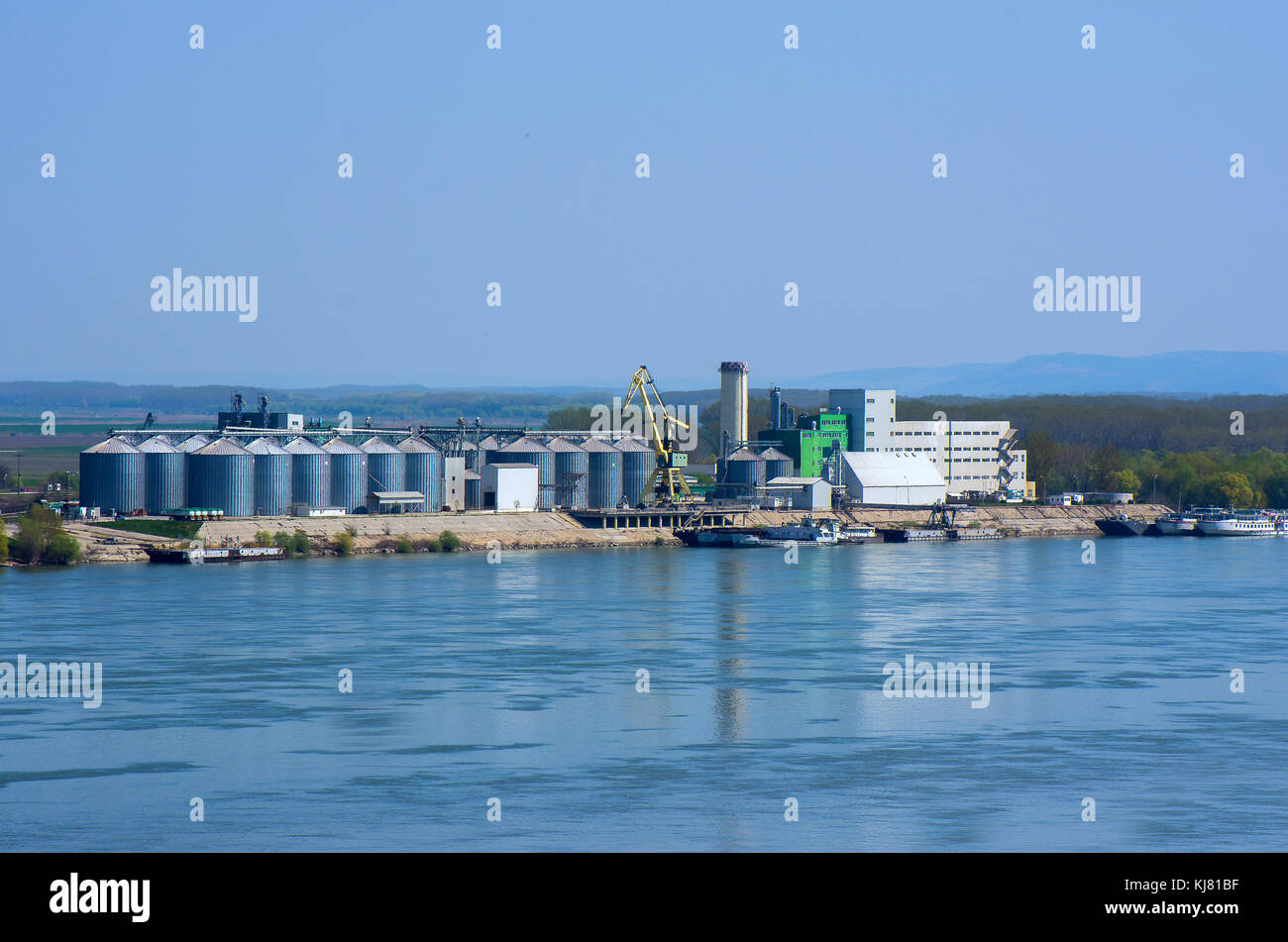 River port with ships, silos, lifting cranes, tanks, warehouses and industrial buildings. Stock Photo