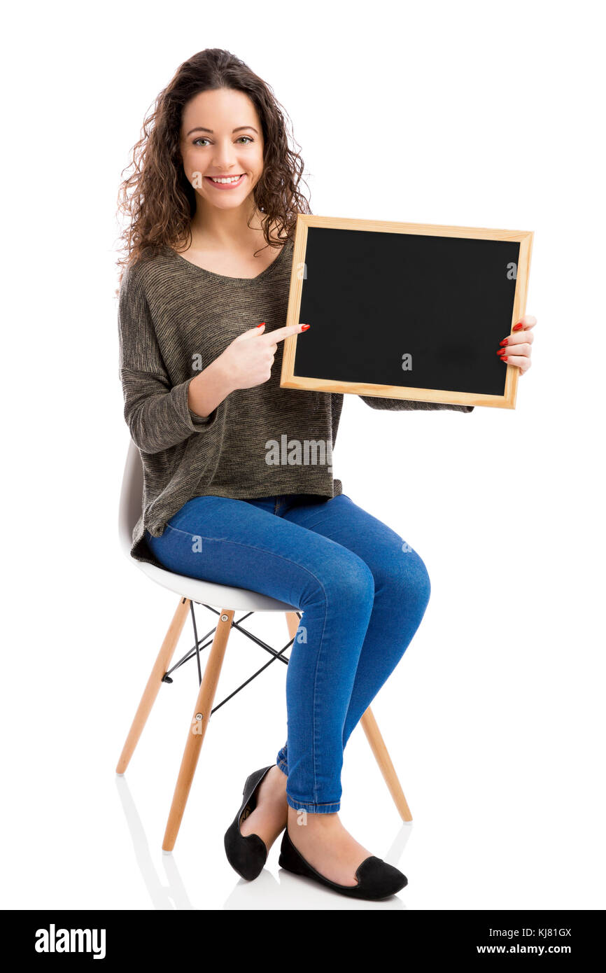 Beautiful and happy woman showing something on a chalkboard Stock Photo