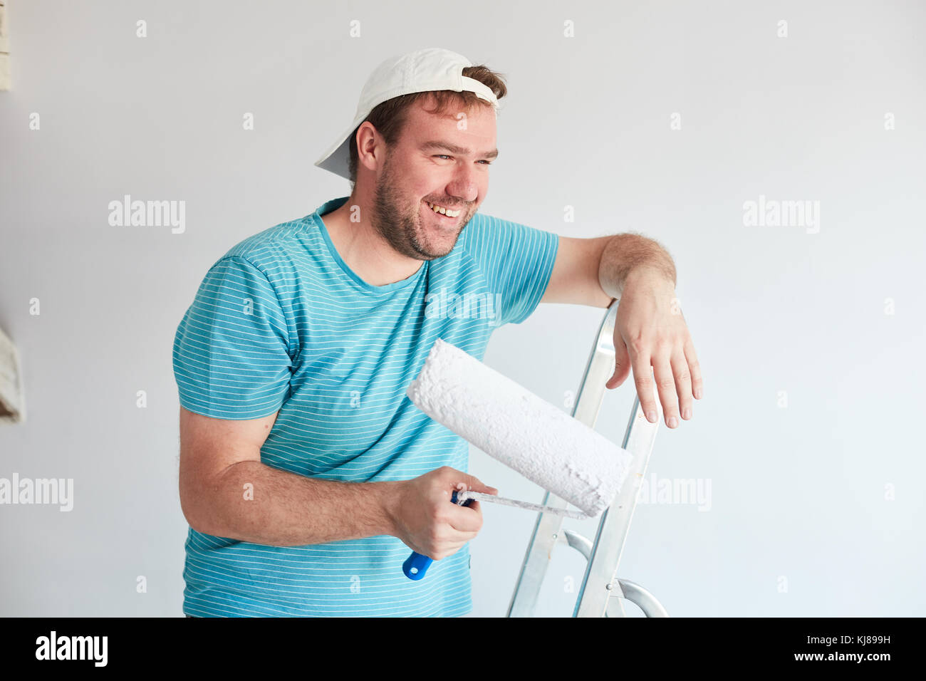 Smiling man holding a roller in front of him Stock Photo