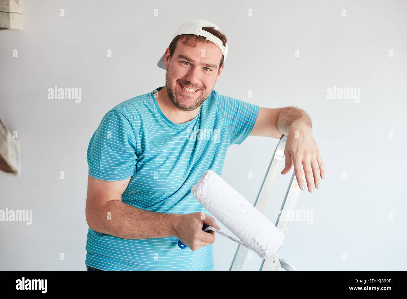 Smiling man holding a roller in front of him Stock Photo