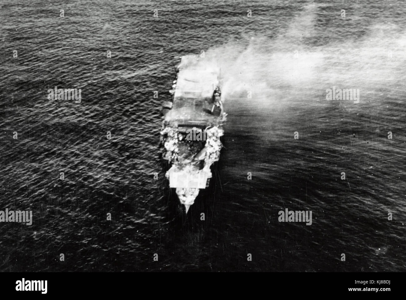 The burning Japanese aircraft carrier Hiryu, photographed by a Yokosuka B4Y aircraft from the carrier Hosho shortly after sunrise on 5 June 1942. Hiryu sank a few hours later. Note the collapsed flight deck over the forward hangar.  Battle of Midway Stock Photo