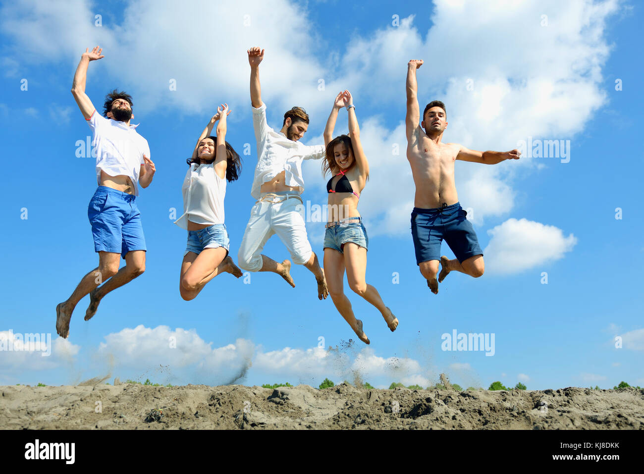 Image of young people jumping together outdoor Stock Photo - Alamy