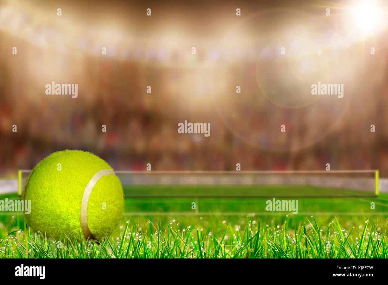Low angle view of tennis ball on grass court and deliberate shallow depth of field on brightly lit stadium background with copy space. Stock Photo