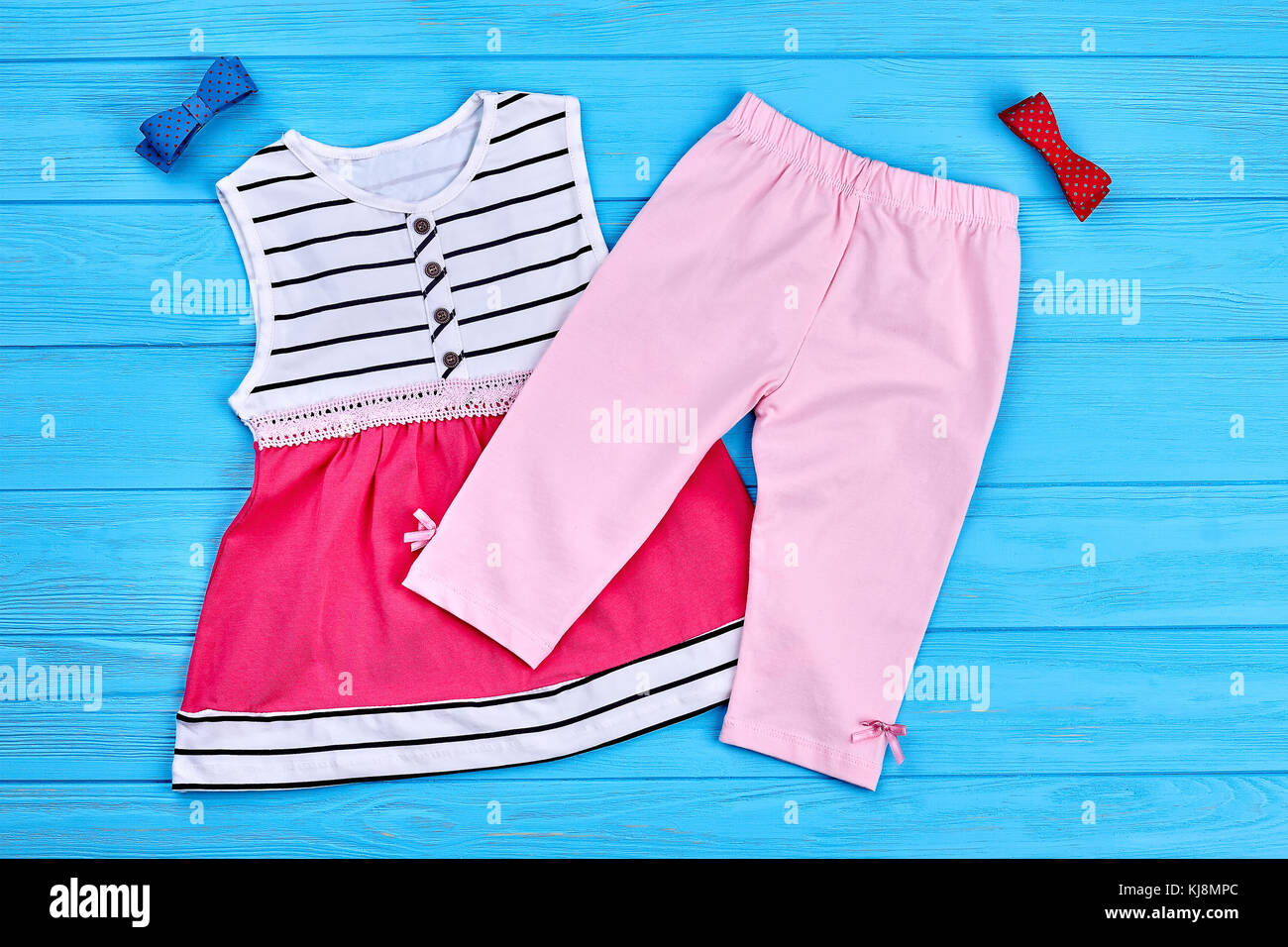 Kids summer fashion background. Babygirl dress, pants and bowtie on