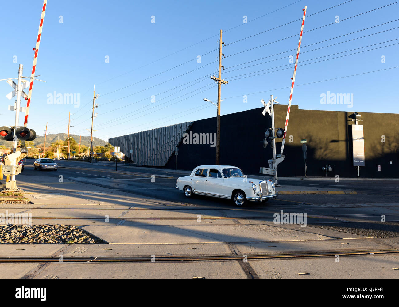 Vintage Mercedes automobile driving across train tracks at the Santa Fe Railyard, New Mexico. Stock Photo