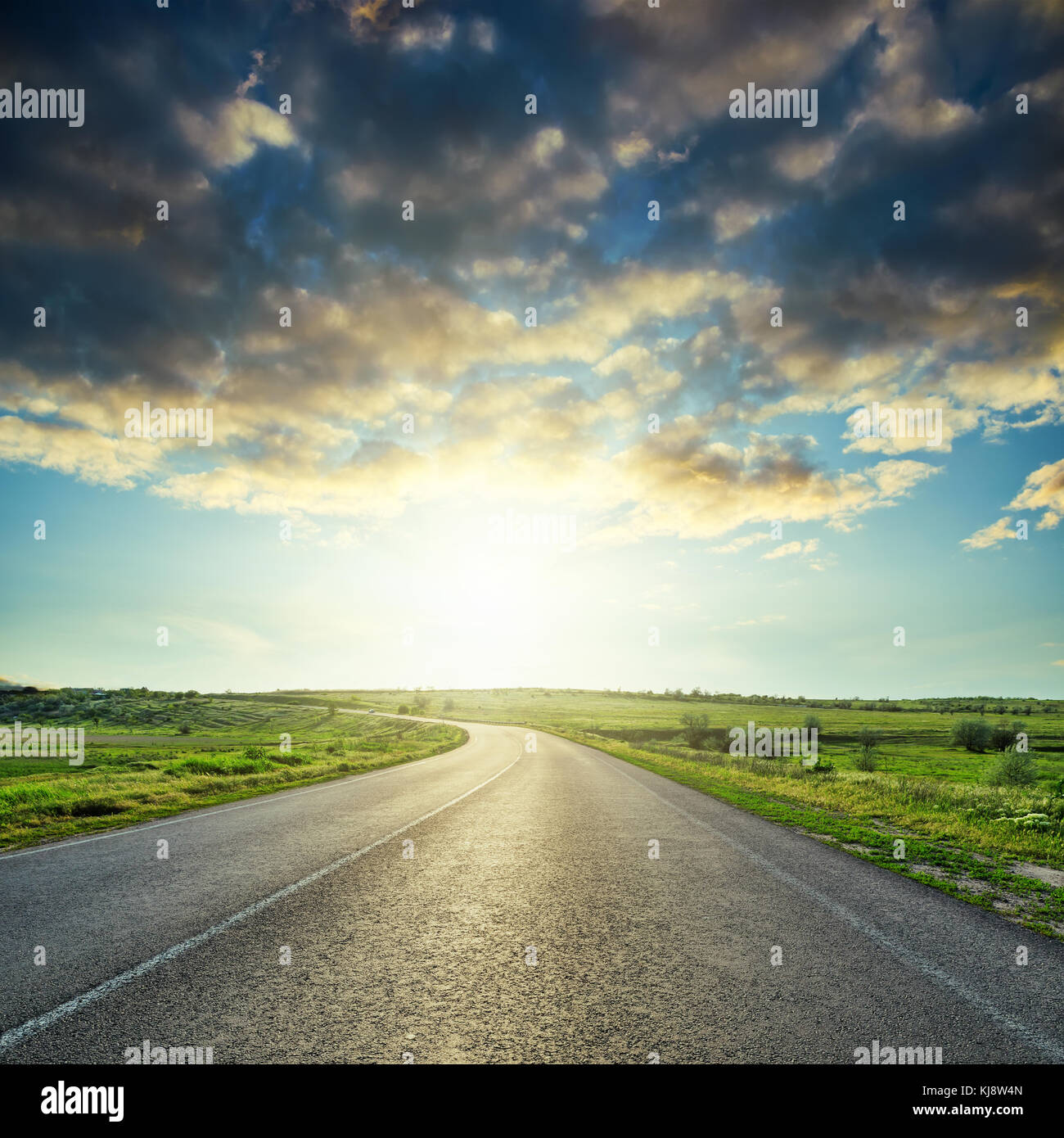 sunset in dramatic clouds over asphalt road Stock Photo - Alamy