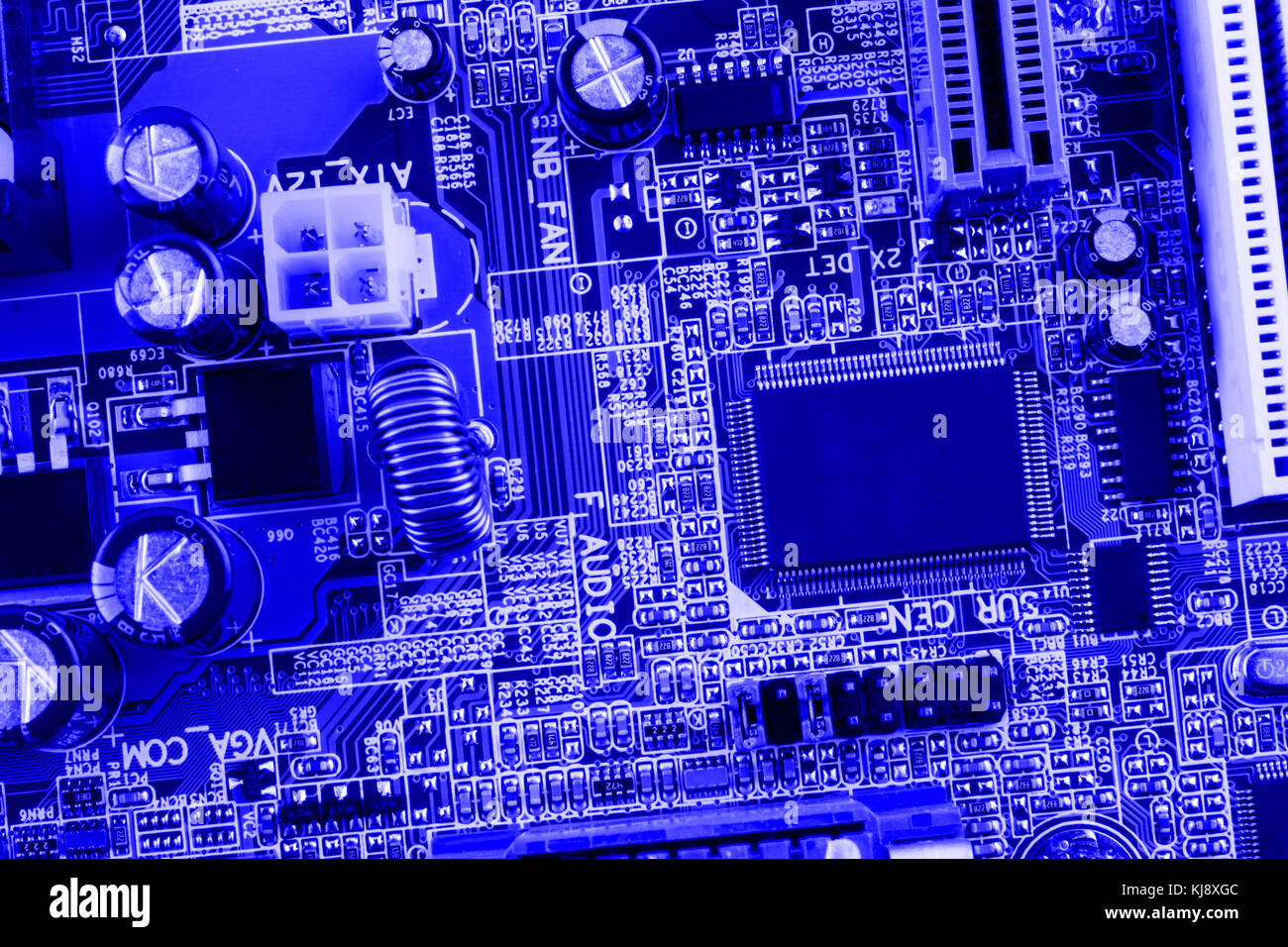 Microchip, filter, capacitors, battery, connectors on the motherboard of a modern computer blue background close macro. Stock Photo
