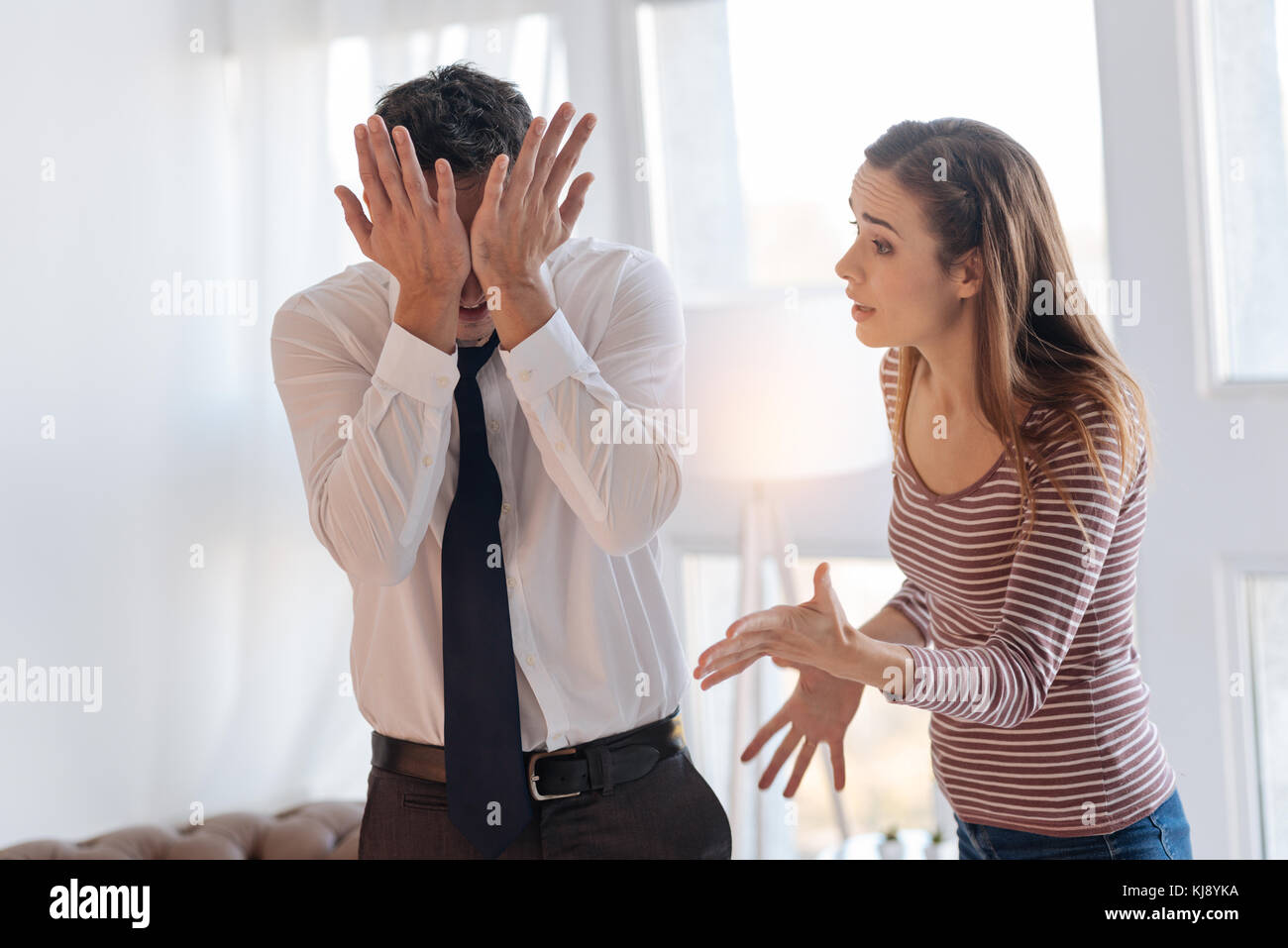 Angry woman blaming her tired irritated husband during their quarrel Stock Photo