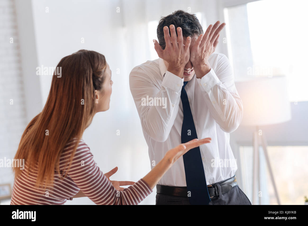 Emotional young man closing his eyes during the quarrel Stock Photo