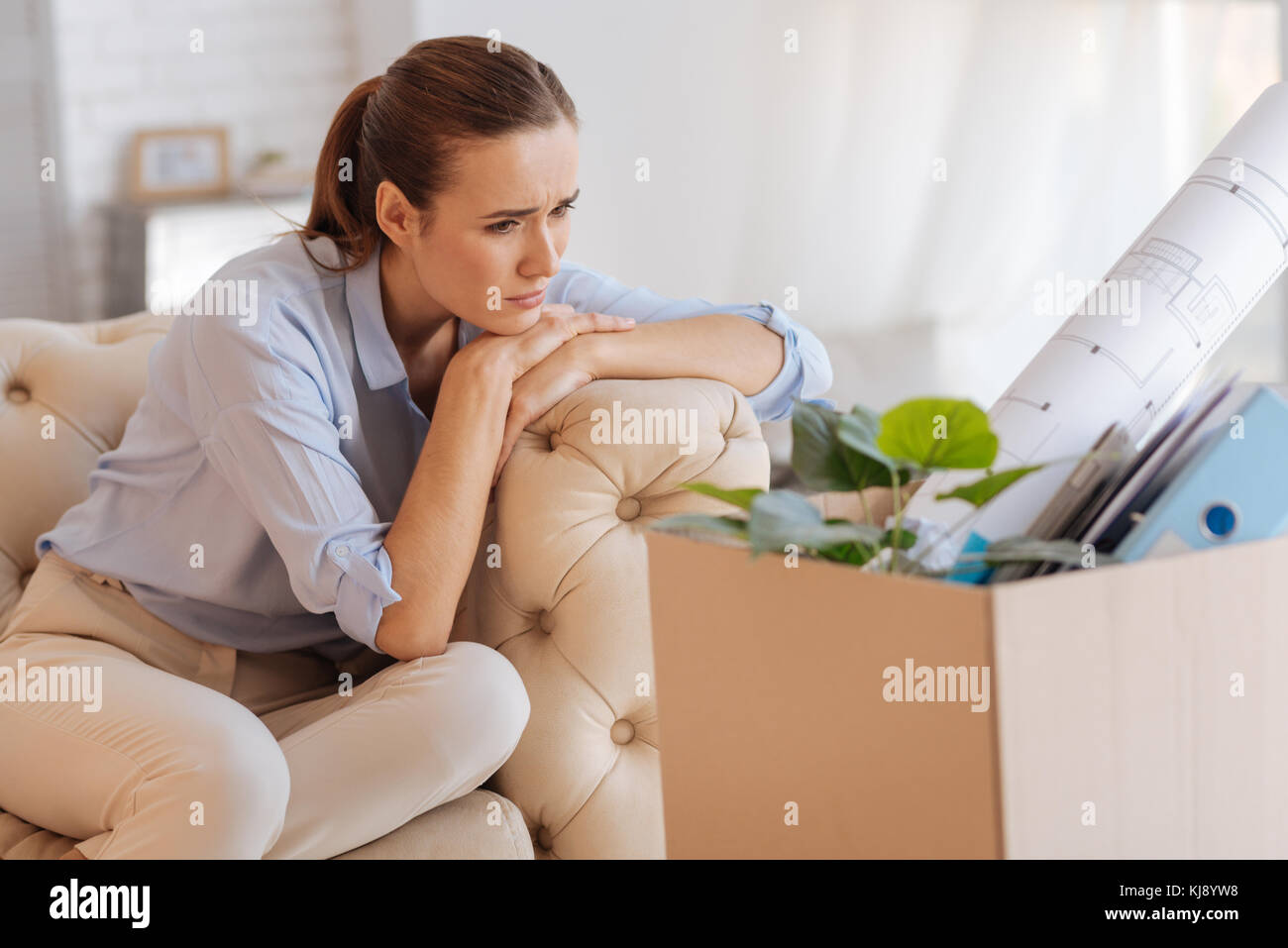 Thoughtful jobless engineer sitting alone and feeling sad Stock Photo
