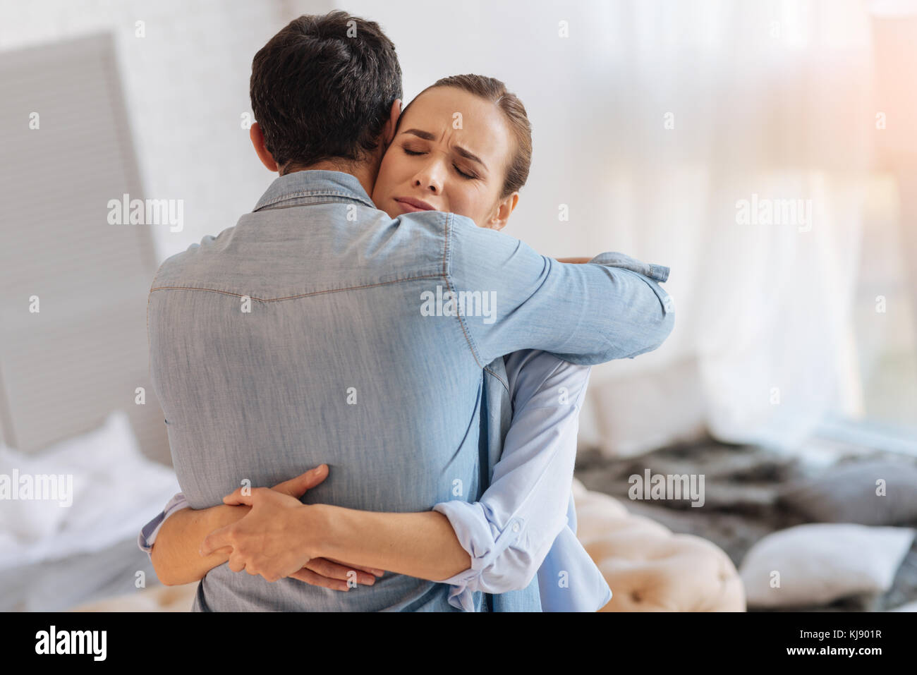 Exhausted dismissed woman hugging her loving husband Stock Photo