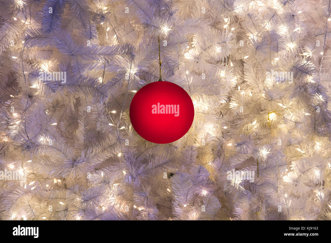 Decorative balls hanging on a Christmas tree with a white needle. Red