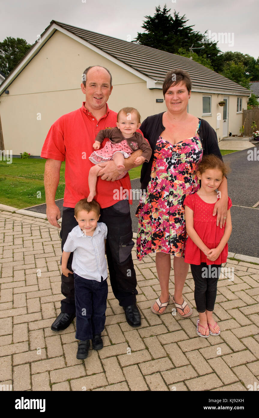 Family standing front of their home Stock Photo - Alamy