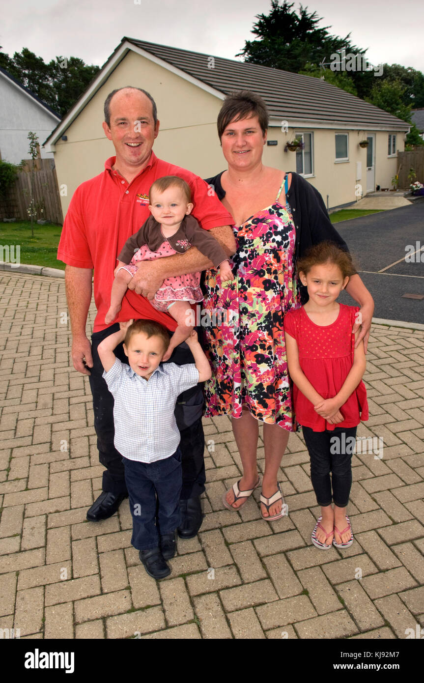 Family standing front of their home Stock Photo - Alamy