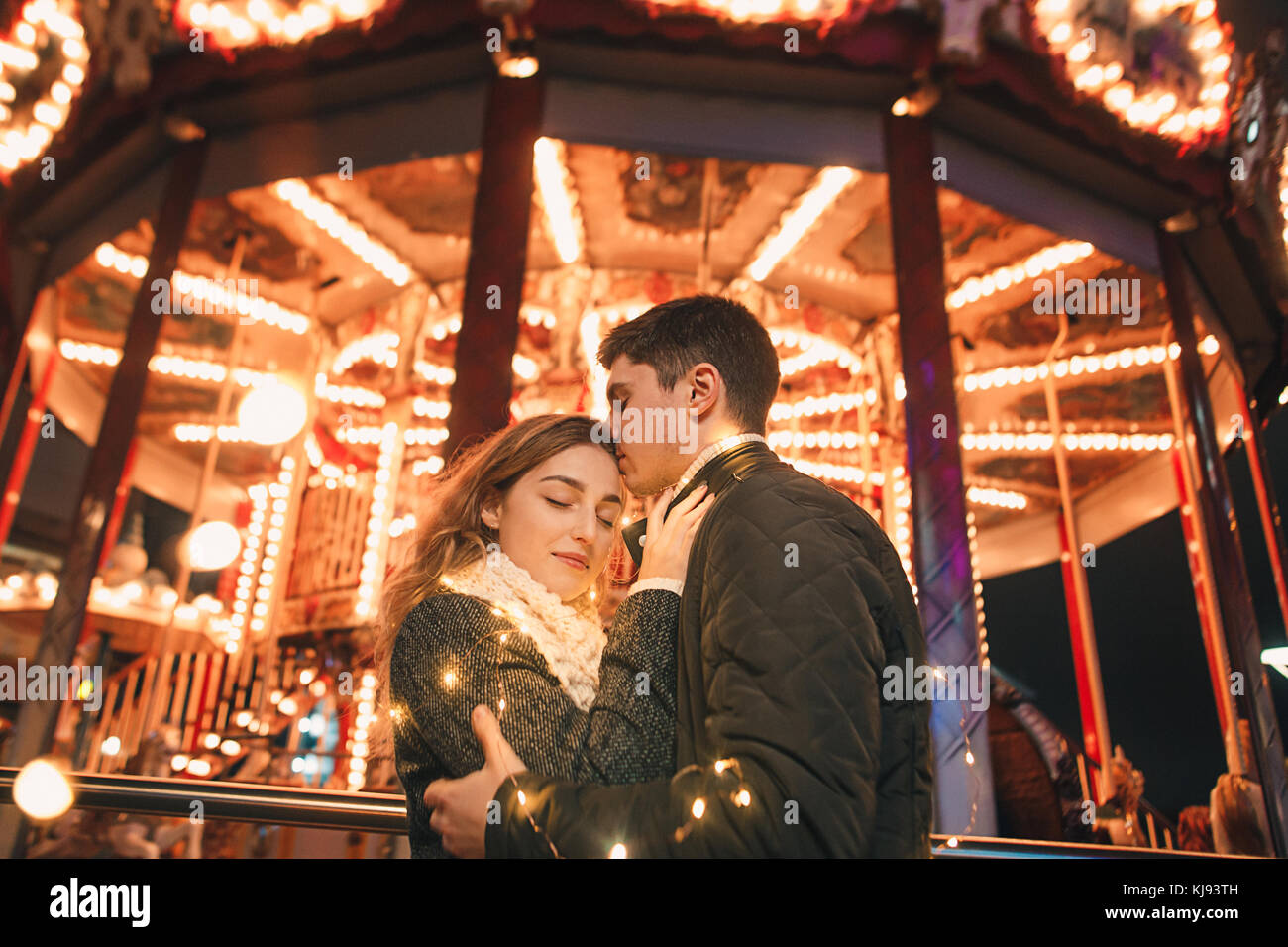 Young couple kissing and hugging outdoor in night street at christmas time Stock Photo