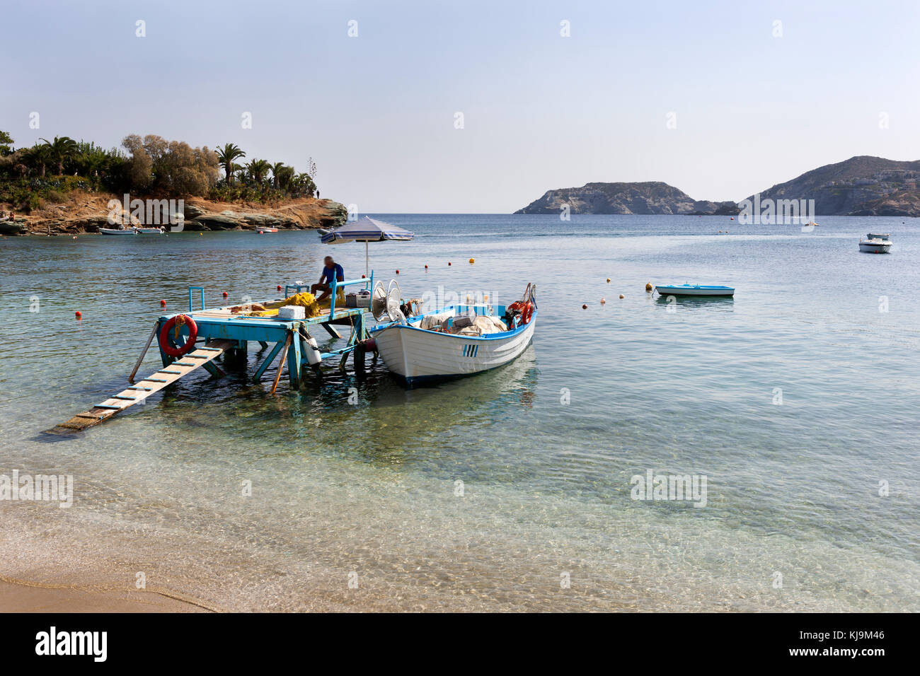 Bay of Agia Pelagia where a fisherman is repairing his nets near the beach on the island  Crete in Greece Stock Photo